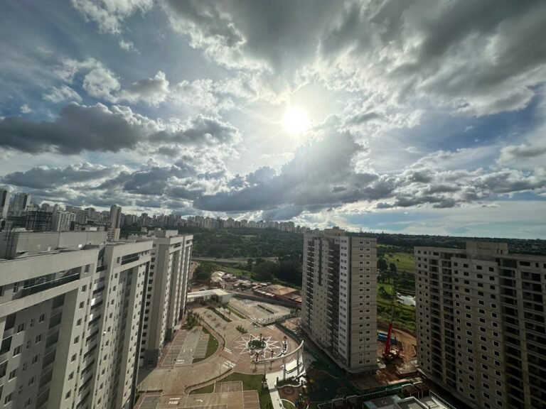 vista da alameda do condomínio com o sol se pondo ao fundo